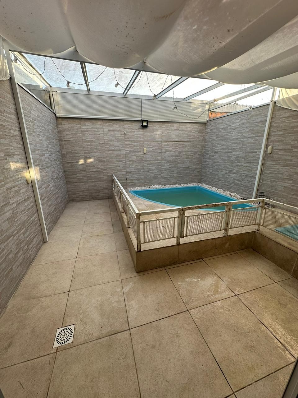 Área externa privativa com piscina cercada e toldo retrátil